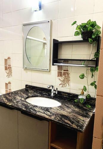 a bathroom with a sink and a mirror at Casa para a temporada com 3 quartos a caminho do centro in Porto Seguro