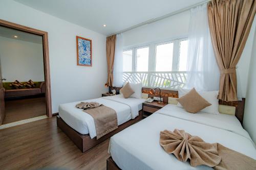 a hotel room with two beds and a window at Ben Tre Riverside Resort in Ben Tre