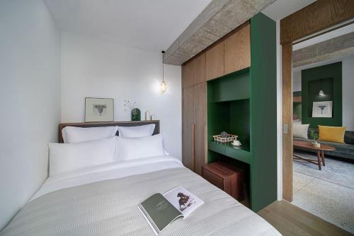 a bedroom with a bed with a book on it at basePLUS-Shanghai Binjiang Serviced Apartment in Shanghai