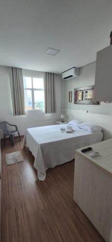 a hotel room with a bed and two chairs at Flats Paris in Lagoa Santa