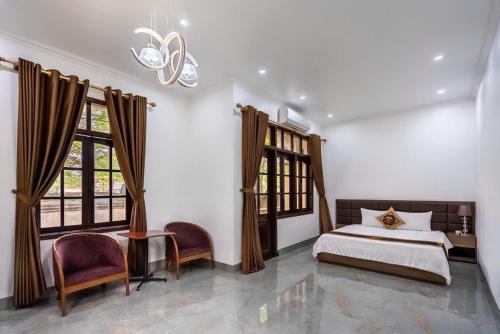 a bedroom with a bed and two windows at Vạn Xuân Royal Hotel in La Phù