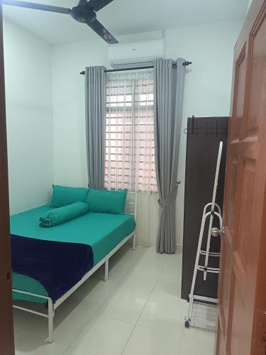 a bedroom with a bed and a ceiling fan at D'sawah Guest House in Kota Bharu