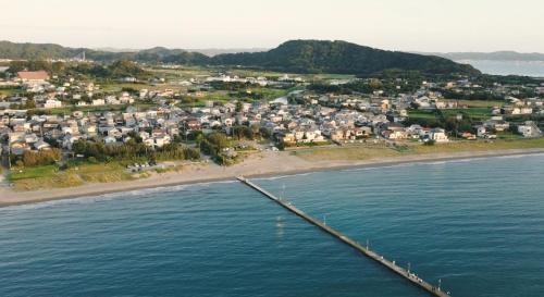 an aerial view of a town on the beach at 砂浜まで10秒 海と桟橋を一望できるHaraoka House in Minamiboso