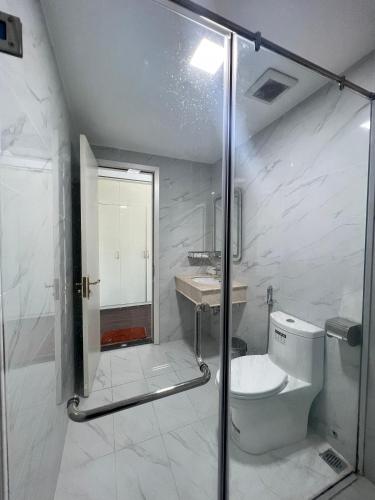 a bathroom with a shower and a toilet and a sink at The Téa Opera Hotel - Hoa Đông Aureum in Châu Cầu