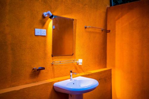 a bathroom with a white sink and a mirror at Walawa Wild Place in Udawalawe