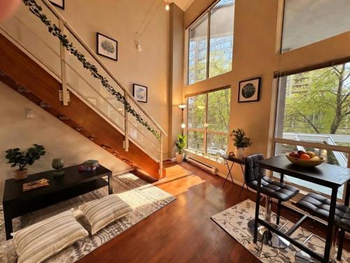a living room with a staircase and a table at The Urban Lofts in Vancouver
