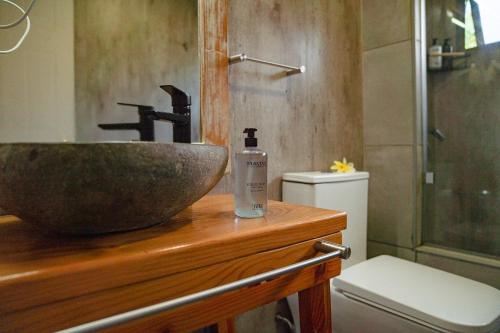 a bathroom with a stone sink and a toilet at Taha Tai in Hanga Roa