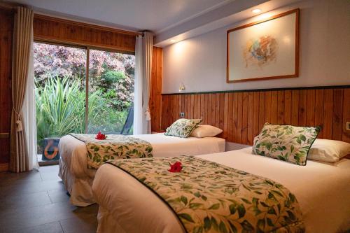 a hotel room with two beds and a window at Taha Tai in Hanga Roa