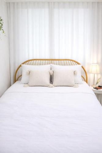 a white bed with white pillows in a bedroom at Shalom Gold Terrace in Paju