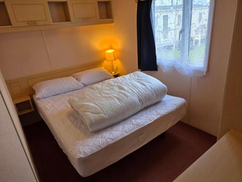 a small bed in a room with a window at Beachside Ingoldmells, 2 bedroom, Wifi in Ingoldmells