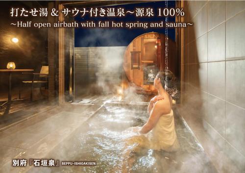 a woman in a bath tub with a train in the background at 石垣泉 in Beppu