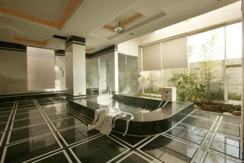 een grote badkamer met een zwart-witte tegelvloer bij 御花園商務旅舘虎尾舘-金花園汽車旅舘066 in Huwei