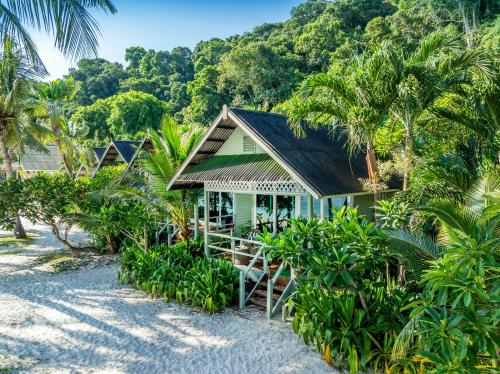 a house on the beach with palm trees at Rawa Island Resort in Mersing