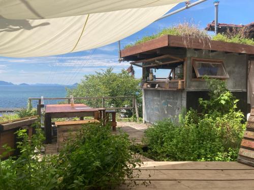 a building with a picnic table and a view of the ocean at Lemon tree hotel in Higashiura