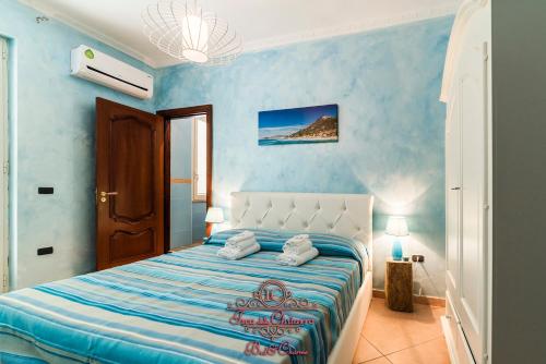 ein blaues Schlafzimmer mit einem großen Bett mit blauen Wänden in der Unterkunft Isca della Chitarra Bed and Charme in Castellabate