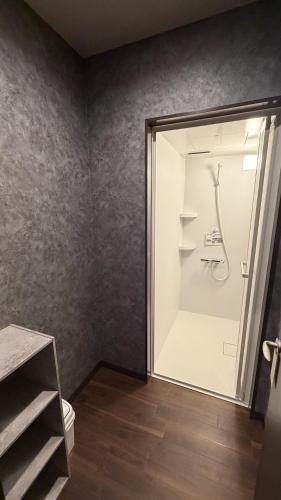 a bathroom with a shower and a toilet in a room at hostel大黒屋 in Miyoshi
