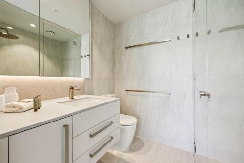 a bathroom with a sink and a toilet and a shower at Miles at Kirra Point 604 in Gold Coast