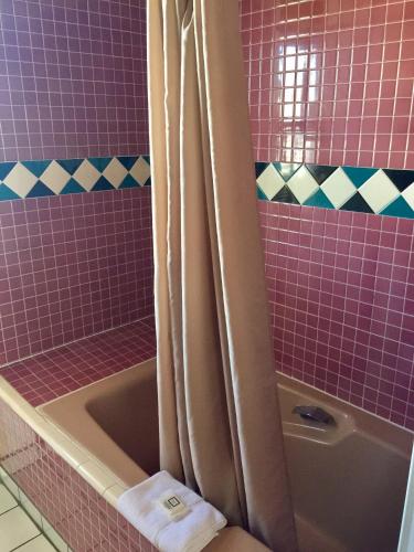 a pink bathroom with a tub and a shower at Guadalupe Inn in Santa Fe