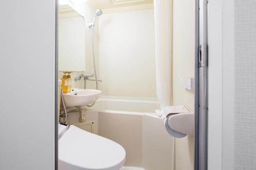 a small bathroom with a toilet and a sink at Flexstay Inn Sakuragicho in Yokohama