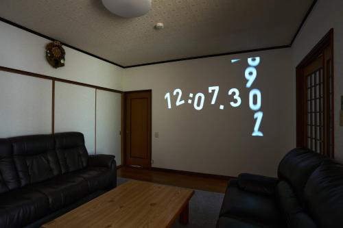 a living room with a clock on the wall at Slow Toya in Lake Toya