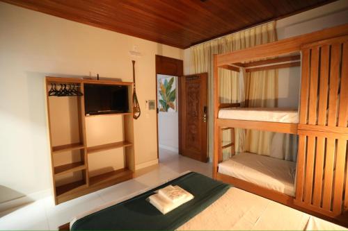 a room with two bunk beds and a tv at Na Casa Hostel in Manaus