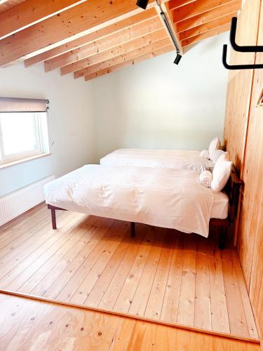 a bed in a room with a wooden floor at Ajito Niseko in Kutchan