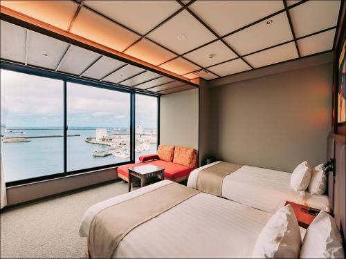 a hotel room with two beds and a large window at Tanegashima Araki Hotel in Nishinoomote