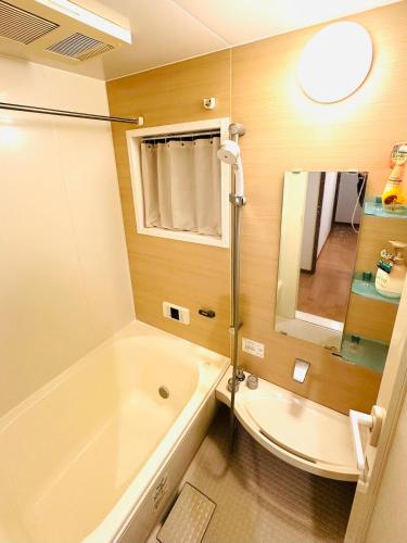 a bathroom with a tub and a toilet and a sink at 清場Kiyoba in Kawaguchi