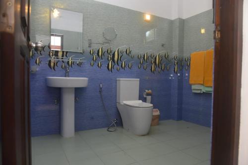 a bathroom with a sink and a toilet and a mirror at The Lark Resort ,induruwa in Induruwa