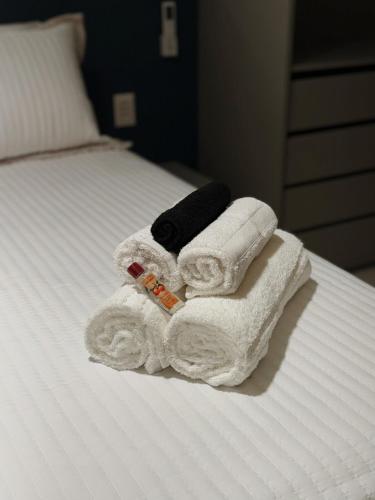 a pile of towels sitting on top of a bed at Art Studio Mare Loft in Salvador