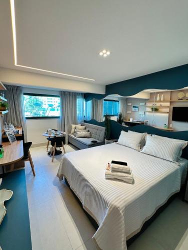 a bedroom with a large bed and a living room at Art Studio Mare Loft in Salvador