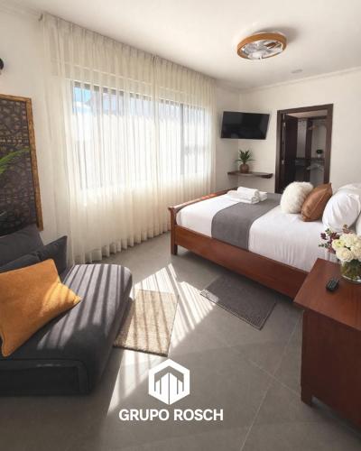 a hotel room with a bed and a couch at Apartamento con Piscina in Las Victorias
