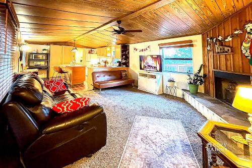 a living room with a leather couch and a television at Ruidoso Mountain Getaway Centrally Located in Ruidoso