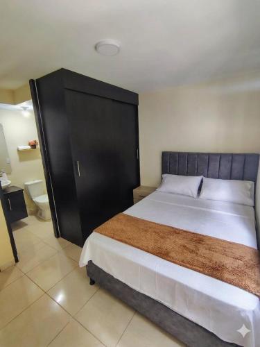 a bedroom with a large bed and a bathroom at Apartamento de 3 habitaciones al Norte de Armenia - excelente ubicación - parqueadero privado in Armenia
