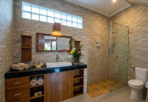 a bathroom with a sink and a glass shower at Sari Murni in Ubud