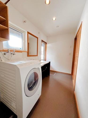 a washing machine in a bathroom with a sink at Ajito Niseko in Kutchan