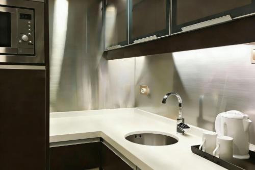a kitchen with a sink and a microwave at Harbour Plaza 8 Degrees in Hong Kong