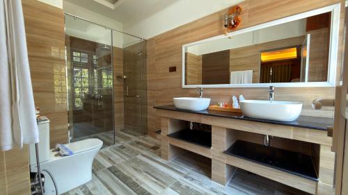 a bathroom with two sinks and a shower at Kingswood Tea Factory in Ramboda