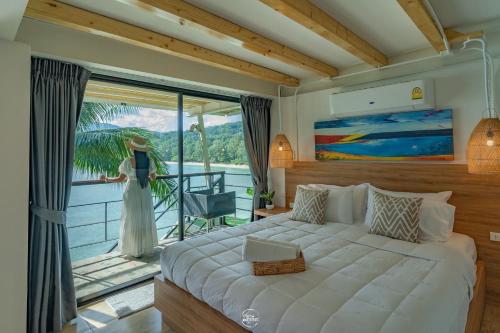 a bedroom with a large bed and a balcony at The Cozy Beachfront Phuket in Patong Beach