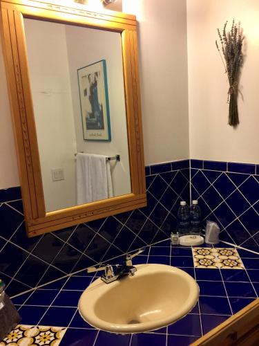 a blue tiled bathroom with a sink and a mirror at Guadalupe Inn in Santa Fe