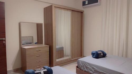 a bedroom with a mirror and a bed and a dresser at chalet - Plumar El Sokhna in Ain Sokhna