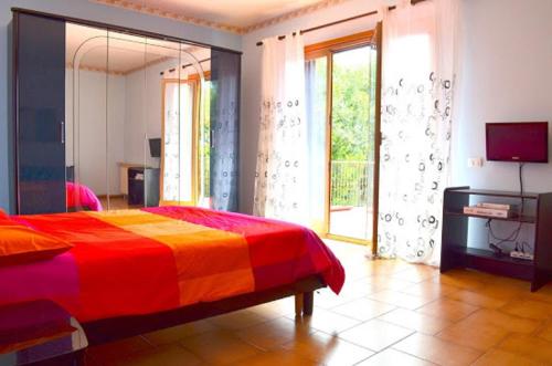 a bedroom with a colorful bed and a television at B&B Le Tre Rose Di Maria in Pedara