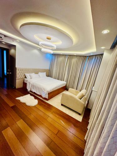 a bedroom with a bed and a couch and a chair at The Crescat Suite by Cinnamon Grand in Colombo