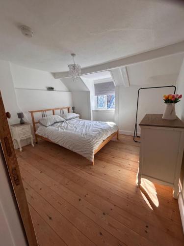 a bedroom with a bed and a wooden floor at Mundesley Cosy cottage in Mundesley