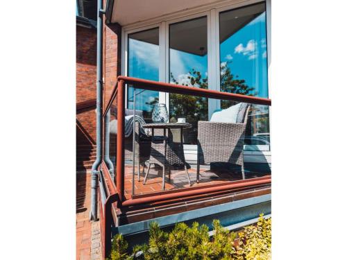 a balcony with a table and chairs on a house at Anker Mal am Hafen in Husum