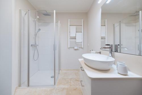 a white bathroom with a sink and a shower at Anker Mal am Hafen in Husum
