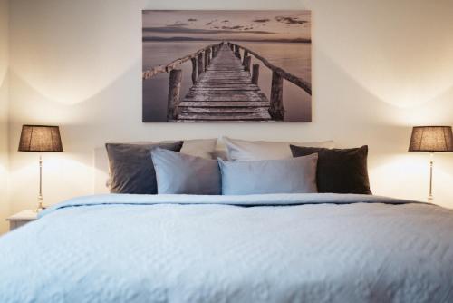 ein Schlafzimmer mit einem Bett und einem Gemälde eines Piers in der Unterkunft Anker Mal Husum Stadt in Husum