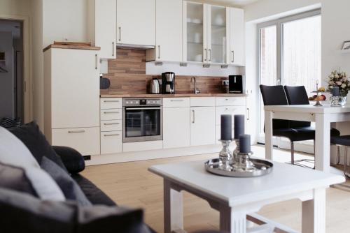 ein Wohnzimmer mit einem Tisch und einer Küche in der Unterkunft Anker Mal Husum Stadt in Husum