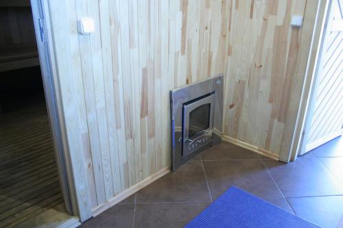 a wood paneled wall with a fireplace in a room at Mikalojiškis in Inturkė