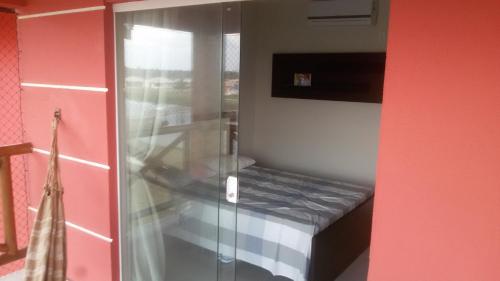 - une douche en verre dans une chambre avec un lit dans l'établissement Apart Resort Villa das Águas, à Praia do Saco